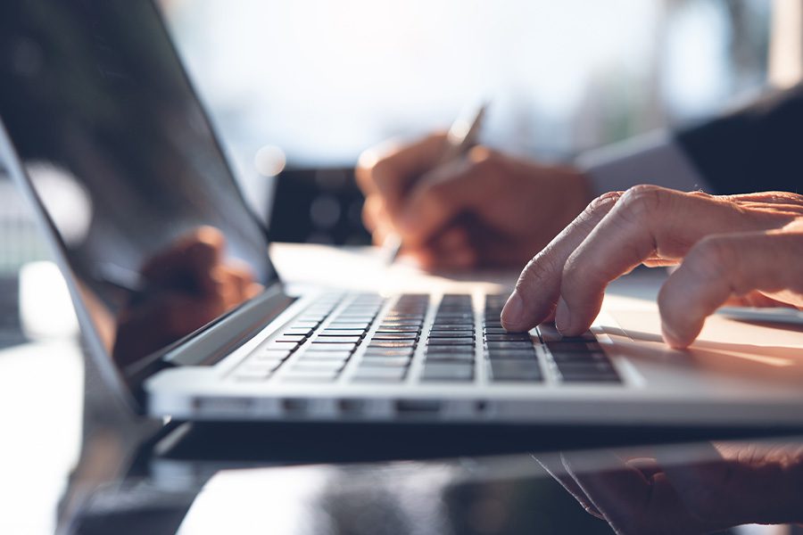 Forms and Resources - Closeup Of Businessman Using a Laptop at His Desk in His Home Office