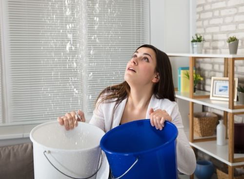 Female filling two buckets with water
